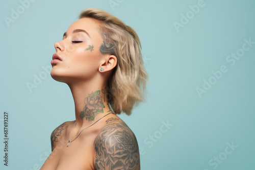 A woman with tattoos on her face and shoulder has her eyes closed photo