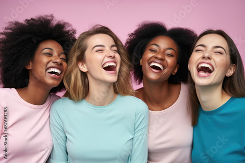 Four women are laughing together with their mouths open photo
