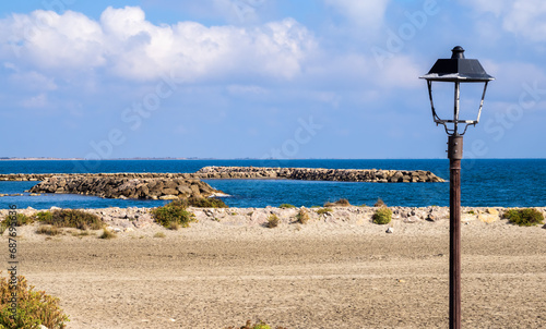 A old lantern on an empty beach of the Mediterranean coast in Saintes Maries de la Mer, Camargue, France photo