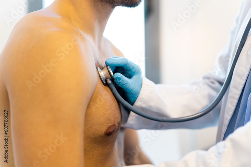 Принти на полотні An unrecognizable doctor uses a stethoscope on the chest of an adult patient to diagnose heart-related pathologies