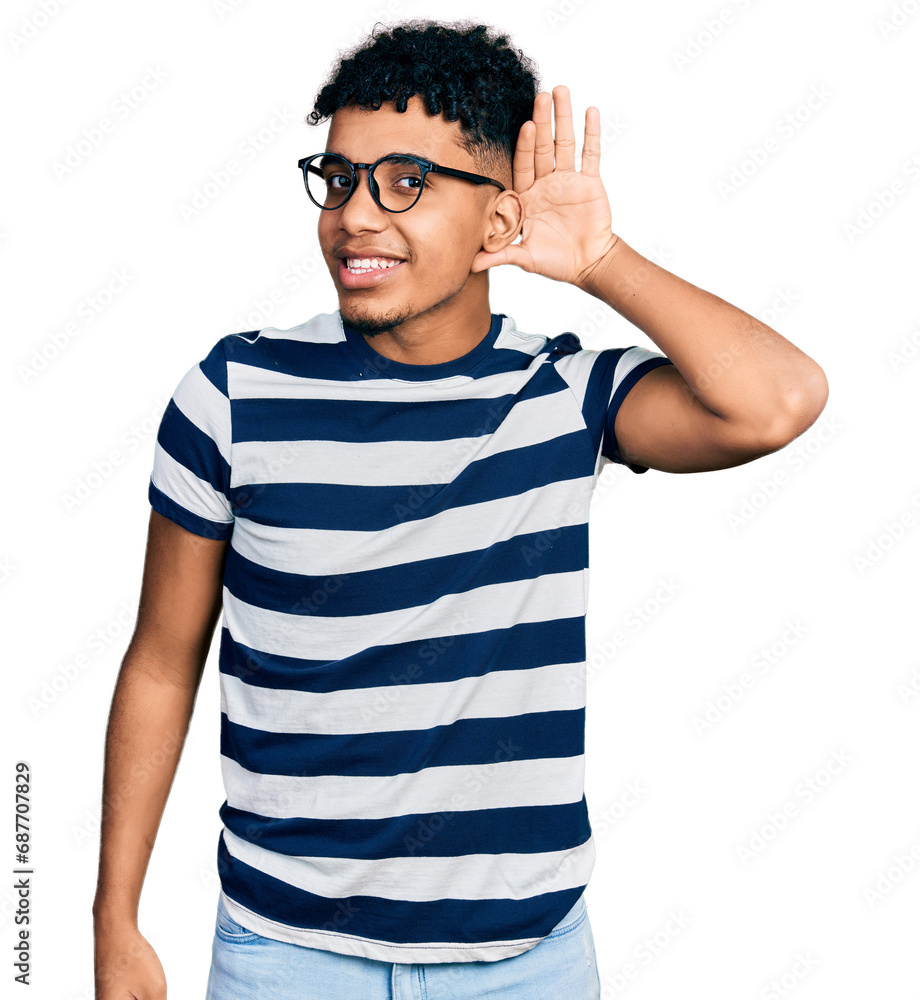 Young african american man wearing casual clothes and glasses smiling with hand over ear listening an hearing to rumor or gossip. deafness concept. Young african american man wearing casual clothes and glasses smiling with hand over ear listening an hearing to rumor or gossip. deafness concept.