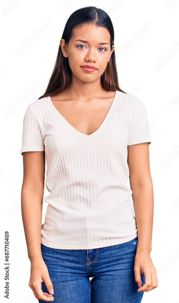 Obraz premium Young beautiful latin girl wearing casual white t shirt with serious expression on face. simple and natural looking at the camera.