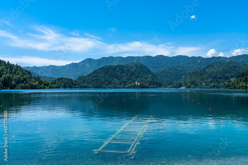 Beautiful idyllic panorama view of Lake Bled with Bled Island, Church of the Mother of God and Slovenian Julian Alps in background in summer with blue sky cloud, Bled, Slovenia photo
