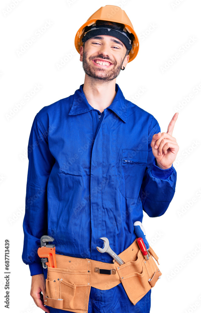 Young hispanic man wearing worker uniform with a big smile on face, pointing with hand finger to the side looking at the camera. Young hispanic man wearing worker uniform with a big smile on face, pointing with hand finger to the side looking at the camera.