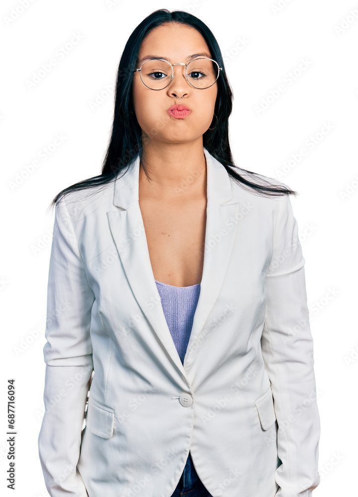 Beautiful hispanic woman with nose piercing wearing business jacket and glasses puffing cheeks with funny face. mouth inflated with air, crazy expression. Beautiful hispanic woman with nose piercing wearing business jacket and glasses puffing cheeks with funny face. mouth inflated with air, crazy expression.