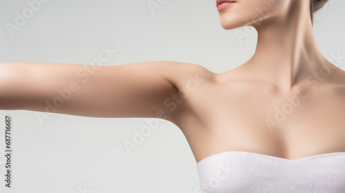 Young beautiful woman show smooth shaved armpits on grey color background with copy space. Laser epilation, electroepilation, removing unwanted hair permanently, banner template. photo