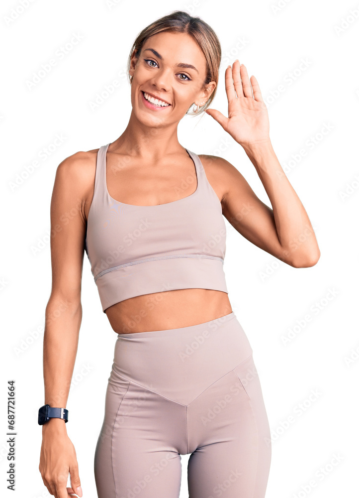 Beautiful caucasian woman wearing sportswear waiving saying hello happy and smiling, friendly welcome gesture Beautiful caucasian woman wearing sportswear waiving saying hello happy and smiling, friendly welcome gesture