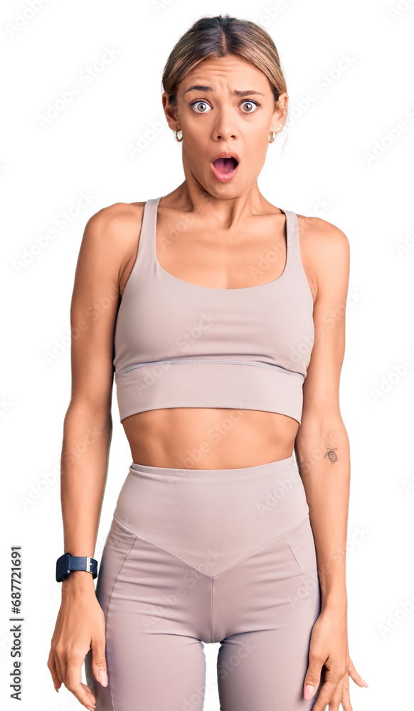 Beautiful caucasian woman wearing sportswear afraid and shocked with surprise and amazed expression, fear and excited face. Beautiful caucasian woman wearing sportswear afraid and shocked with surprise and amazed expression, fear and excited face.