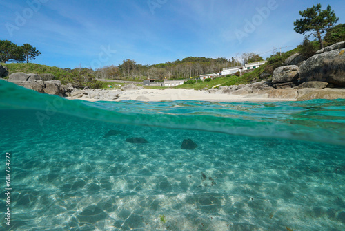 Beach with sand and rocks on the Atlantic coast in Spain, split view over and under water surface, natural scene, Galicia, Rias Baixas, Bueu