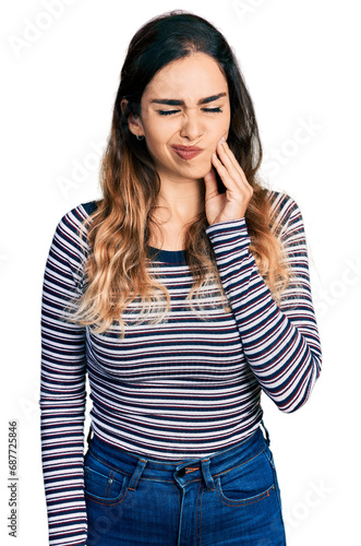 Beautiful hispanic woman wearing casual striped shirt touching mouth with hand with painful expression because of toothache or dental illness on teeth. dentist