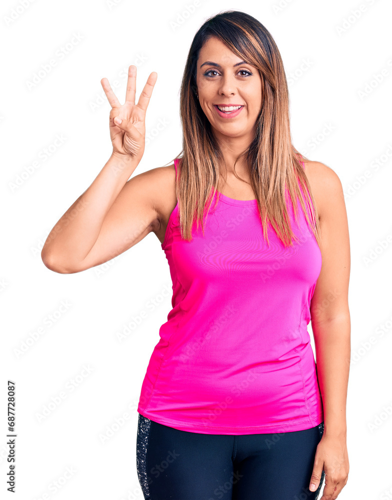 Young beautiful woman wearing sportswear showing and pointing up with fingers number three while smiling confident and happy. Young beautiful woman wearing sportswear showing and pointing up with fingers number three while smiling confident and happy.