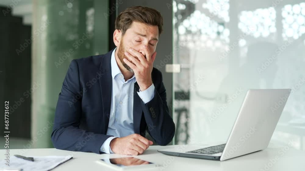 Upset businessman has depression suffering from mental pain sitting at workplace in modern office. Sad male holds his head with his hands, has personal problems, worries, feels despair, disappointment Upset businessman has depression suffering from mental pain sitting at workplace in modern office. Sad male holds his head with his hands, has personal problems, worries, feels despair, disappointment