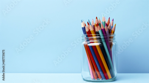 A jar of various colored pencils is placed on a white surface against a solid blue background, creating a vibrant and creative atmosphere. ai generative photo