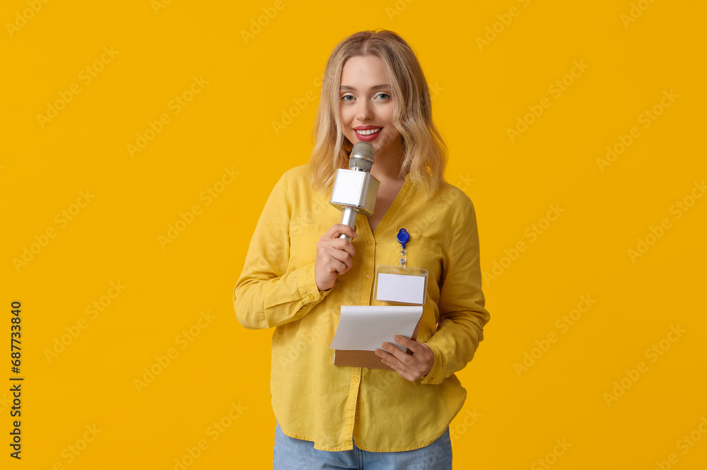 Portrait of female journalist with microphone and notebook taking interview on orange background Portrait of female journalist with microphone and notebook taking interview on orange background