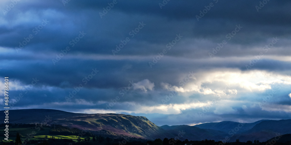Clouds over the mountains with sunlight beam, landscape background