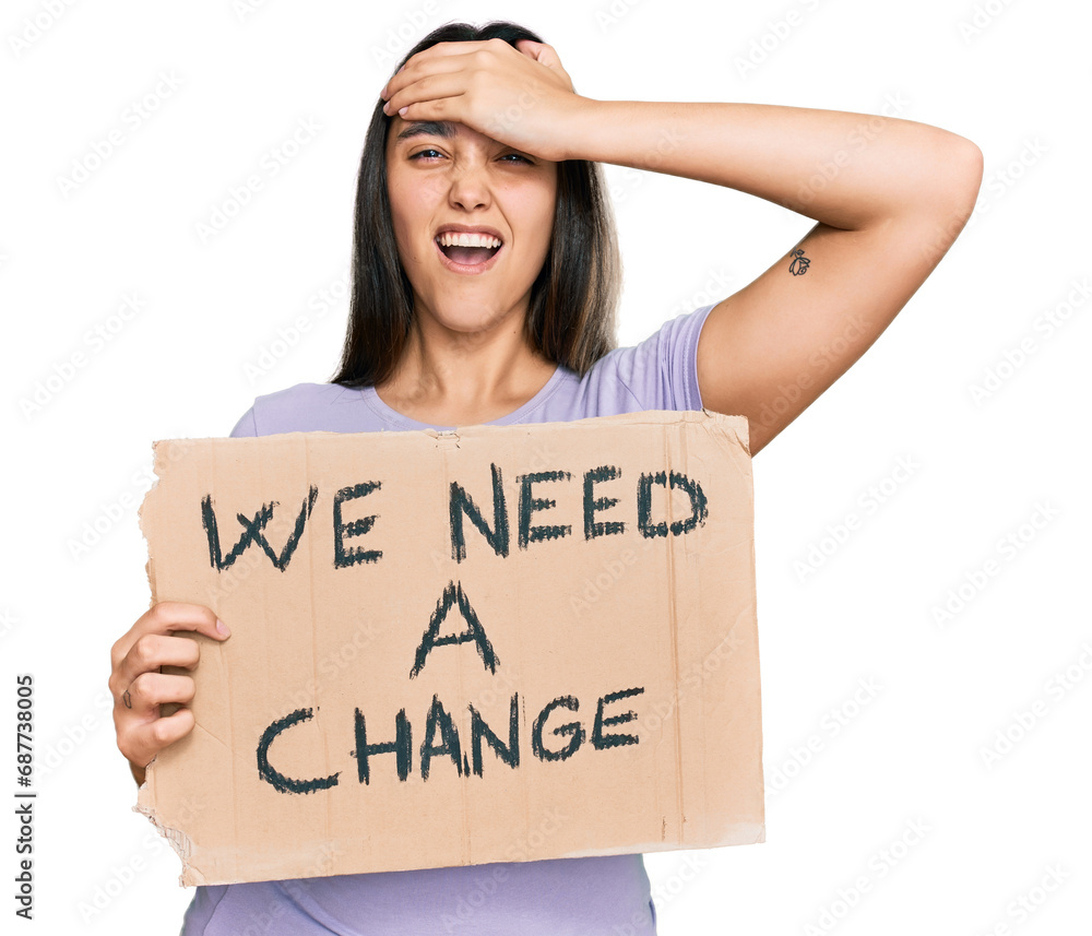 Young hispanic woman holding we need a change banner stressed and frustrated with hand on head, surprised and angry face Young hispanic woman holding we need a change banner stressed and frustrated with hand on head, surprised and angry face