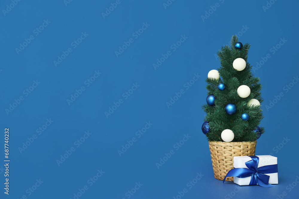 Small Christmas tree with gift on blue background