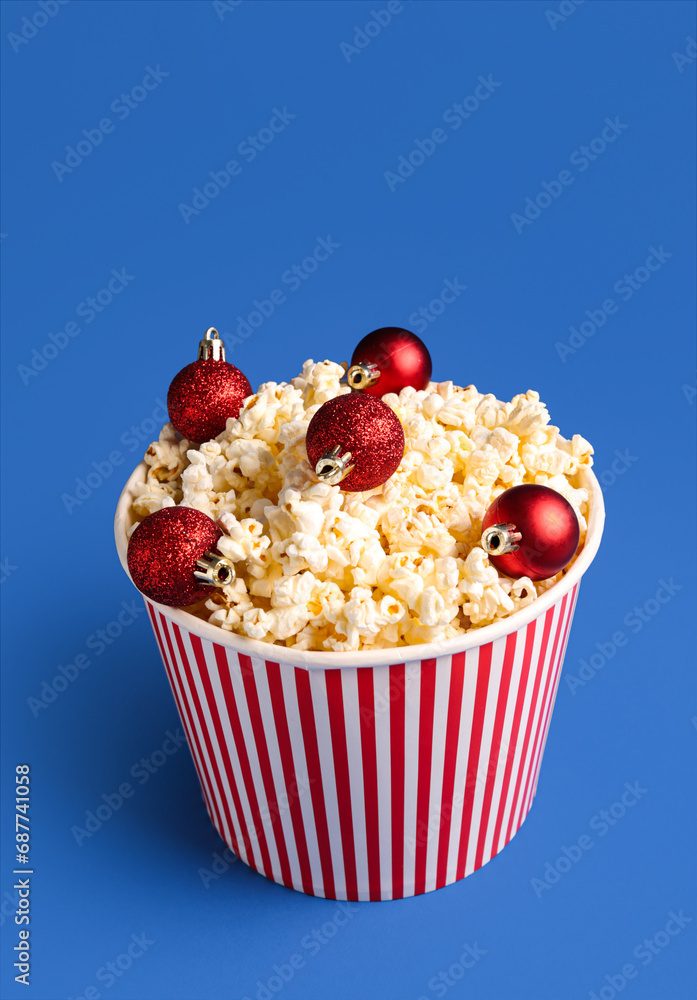 Bucket of popcorn with Christmas tree balls on blue background Bucket of popcorn with Christmas tree balls on blue background