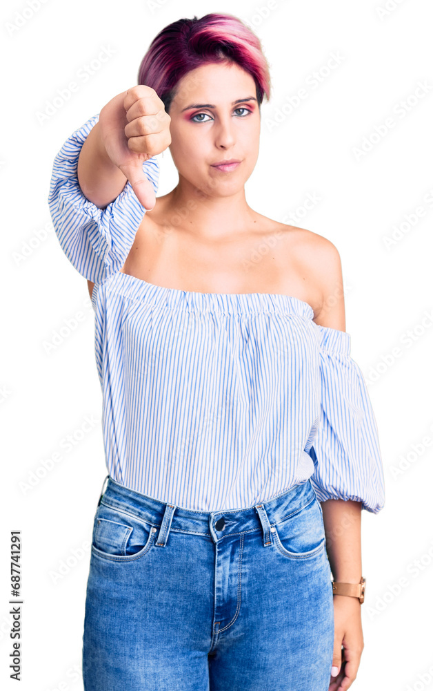 Young beautiful woman with pink hair wearing casual clothes looking unhappy and angry showing rejection and negative with thumbs down gesture. bad expression. Young beautiful woman with pink hair wearing casual clothes looking unhappy and angry showing rejection and negative with thumbs down gesture. bad expression.