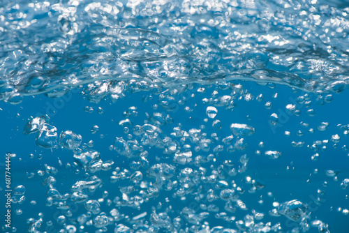 Bluewater bubbles on the surface ripples. Defocus blurred transparent white-black colored clear calm water surface texture with splash and bubbles. Water waves with shining pattern texture background