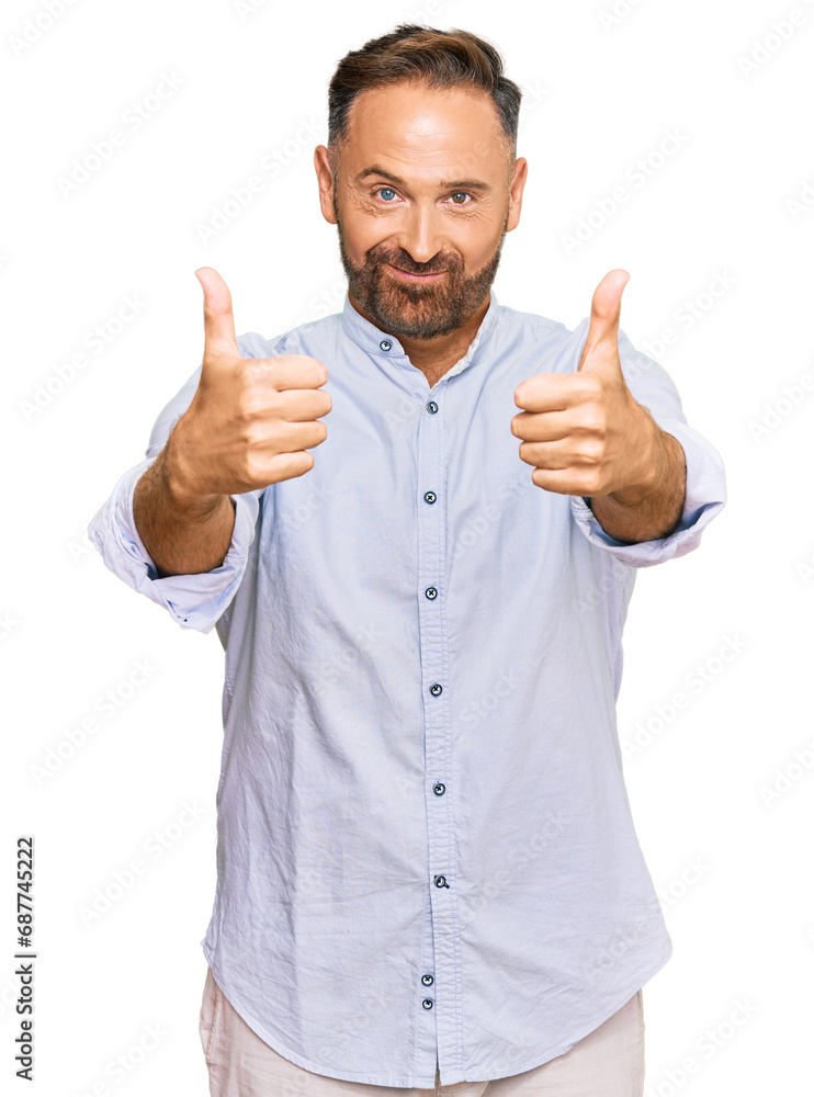 Handsome middle age man wearing business shirt approving doing positive gesture with hand, thumbs up smiling and happy for success. winner gesture. Handsome middle age man wearing business shirt approving doing positive gesture with hand, thumbs up smiling and happy for success. winner gesture.
