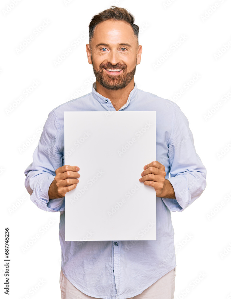 Handsome middle age man holding blank empty banner looking positive and happy standing and smiling with a confident smile showing teeth Handsome middle age man holding blank empty banner looking positive and happy standing and smiling with a confident smile showing teeth