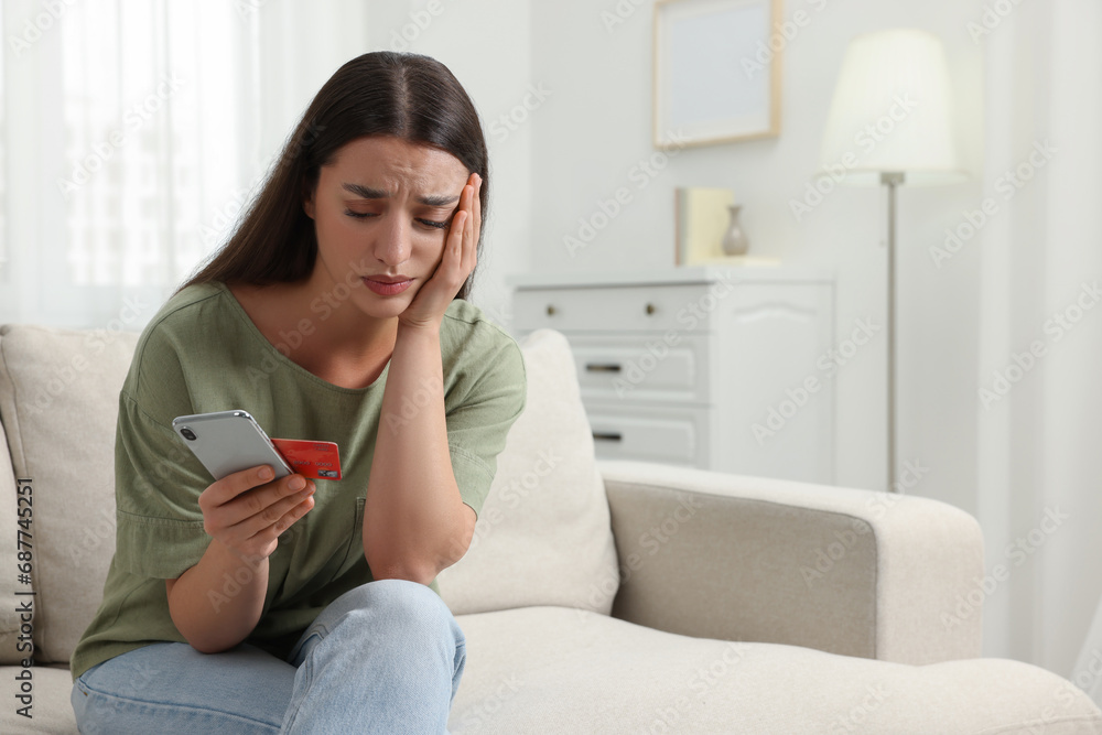 Stressed woman with credit card and smartphone at home. Be careful - fraud Stressed woman with credit card and smartphone at home. Be careful - fraud
