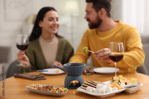 Affectionate couple enjoying chocolate fondue during romantic date indoors  selective focus