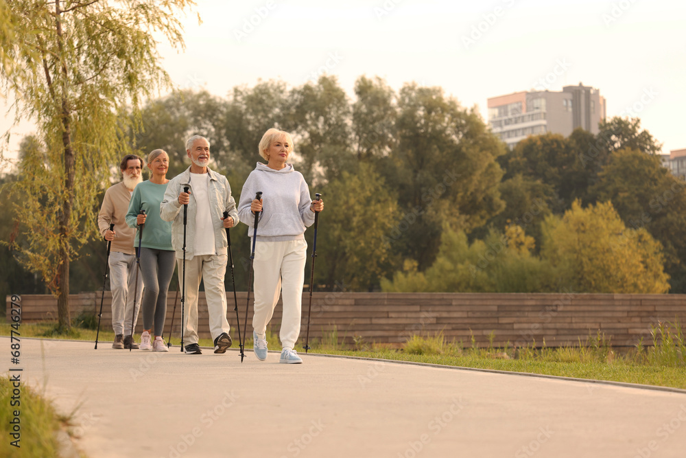 Group of senior people performing Nordic walking outdoors, space for text. Low angle view Group of senior people performing Nordic walking outdoors, space for text. Low angle view