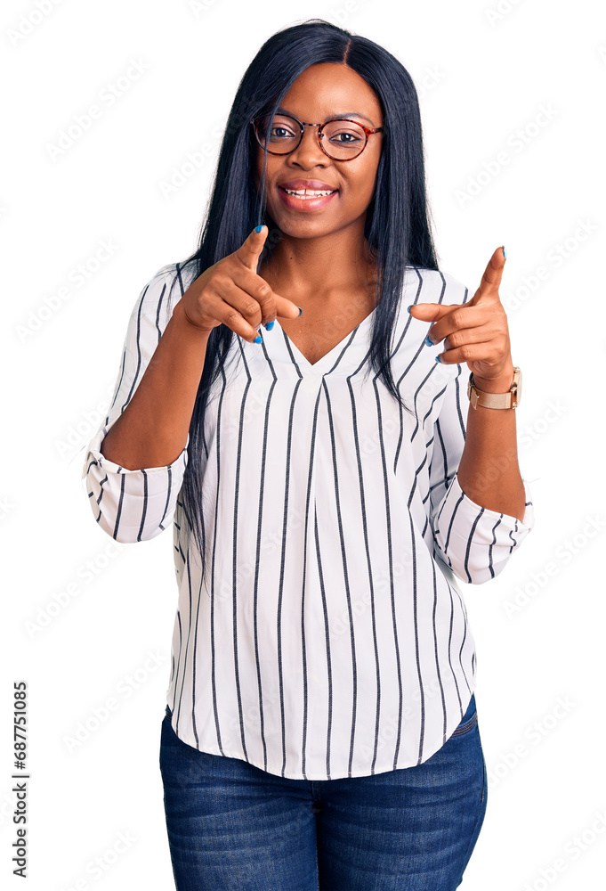 Young african american woman wearing casual clothes and glasses pointing fingers to camera with happy and funny face. good energy and vibes. Young african american woman wearing casual clothes and glasses pointing fingers to camera with happy and funny face. good energy and vibes.