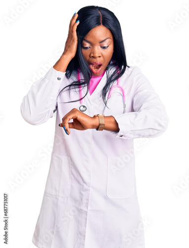 Young african american woman wearing doctor stethoscope looking at the watch time worried  afraid of getting late