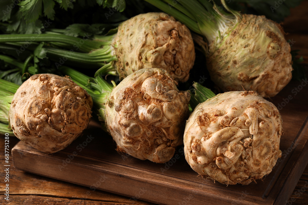 Fototapeta premium Fresh raw celery roots on wooden table, closeup