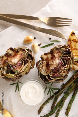 Tasty grilled artichoke served on table, top view