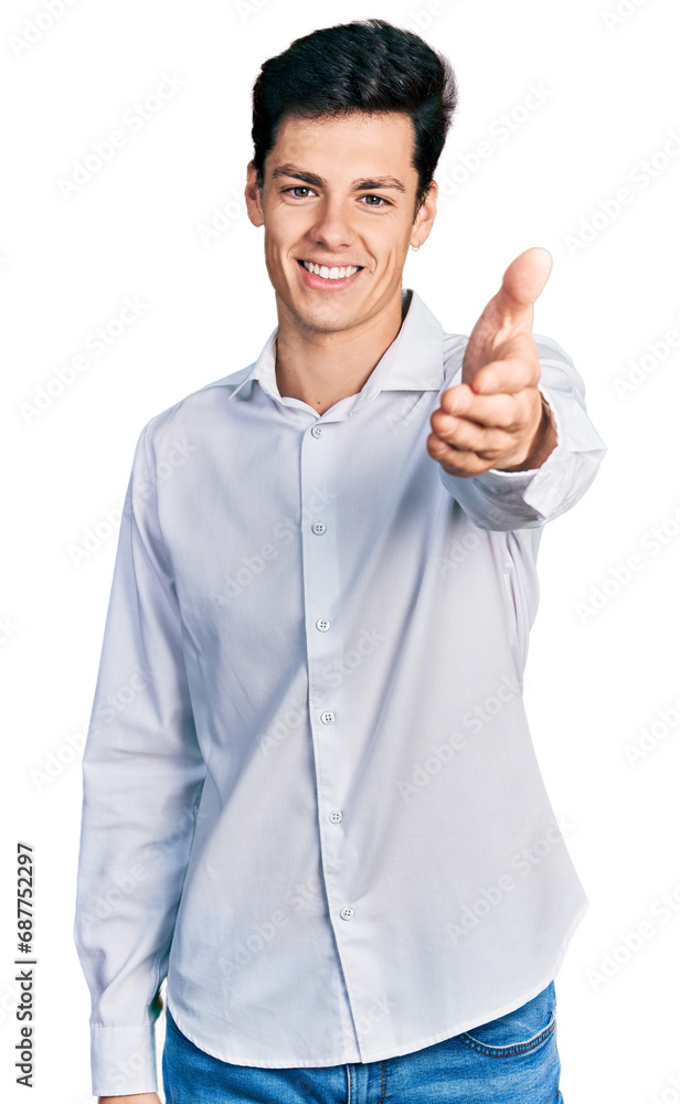 Young hispanic business man wearing business clothes smiling friendly offering handshake as greeting and welcoming. successful business. Young hispanic business man wearing business clothes smiling friendly offering handshake as greeting and welcoming. successful business.