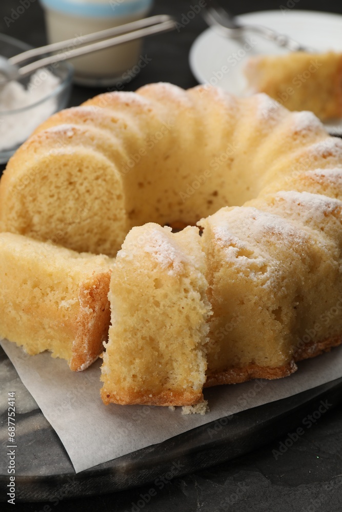 Delicious freshly baked sponge cake on black table, closeup