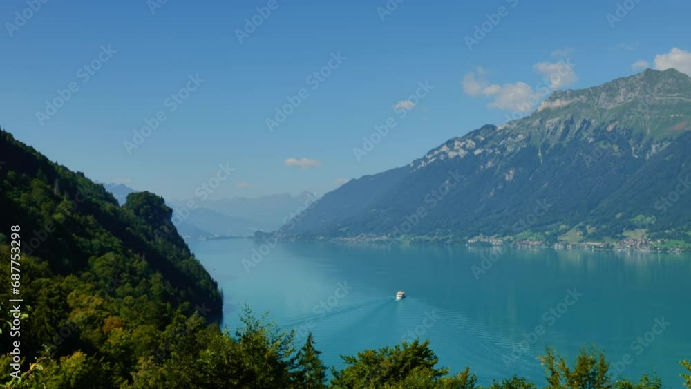 Passenger Ship on Lake Brienz with Mountainscape in a Sunny Summer Day with Blue Sky and Clouds in Giessbach, Brienz, Bernese Oberland, Bern Canton, Switzerland. (Time Lapse) Passenger Ship on Lake Brienz with Mountainscape in a Sunny Summer Day with Blue Sky and Clouds in Giessbach, Brienz, Bernese Oberland, Bern Canton, Switzerland. (Time Lapse)