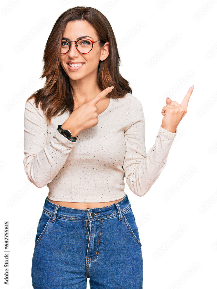 Young brunette woman wearing casual clothes and glasses smiling and looking at the camera pointing with two hands and fingers to the side. Young brunette woman wearing casual clothes and glasses smiling and looking at the camera pointing with two hands and fingers to the side.