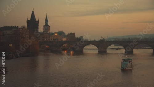 landscape with Vltava river, Karlov most and boat at sunset in autumn in Prague, Czech Republic.