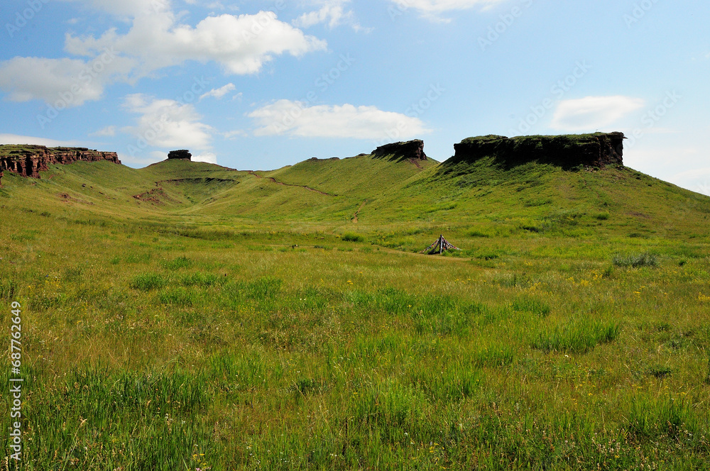 View from the bottom of the hollow on the stone formations along the edges of the high hill. Mountain range View from the bottom of the hollow on the stone formations along the edges of the high hill. Mountain range