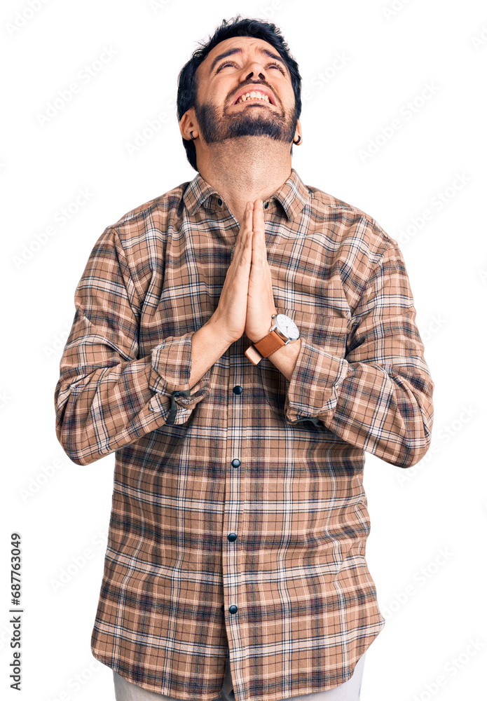 Young hispanic man wearing casual clothes begging and praying with hands together with hope expression on face very emotional and worried. begging. Young hispanic man wearing casual clothes begging and praying with hands together with hope expression on face very emotional and worried. begging.