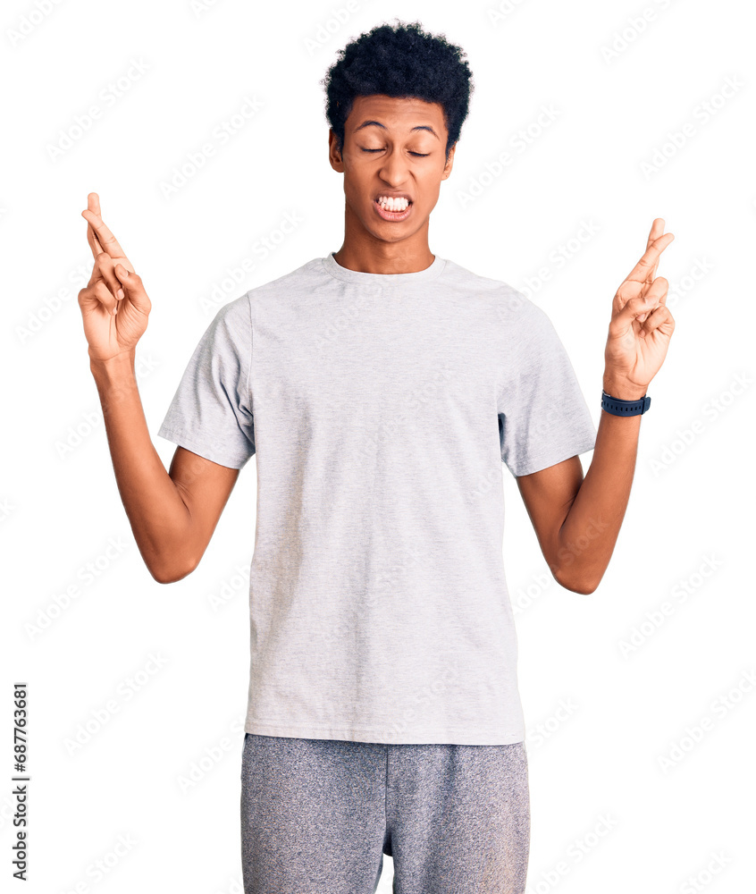 Young african american man wearing casual clothes gesturing finger crossed smiling with hope and eyes closed. luck and superstitious concept. Young african american man wearing casual clothes gesturing finger crossed smiling with hope and eyes closed. luck and superstitious concept.