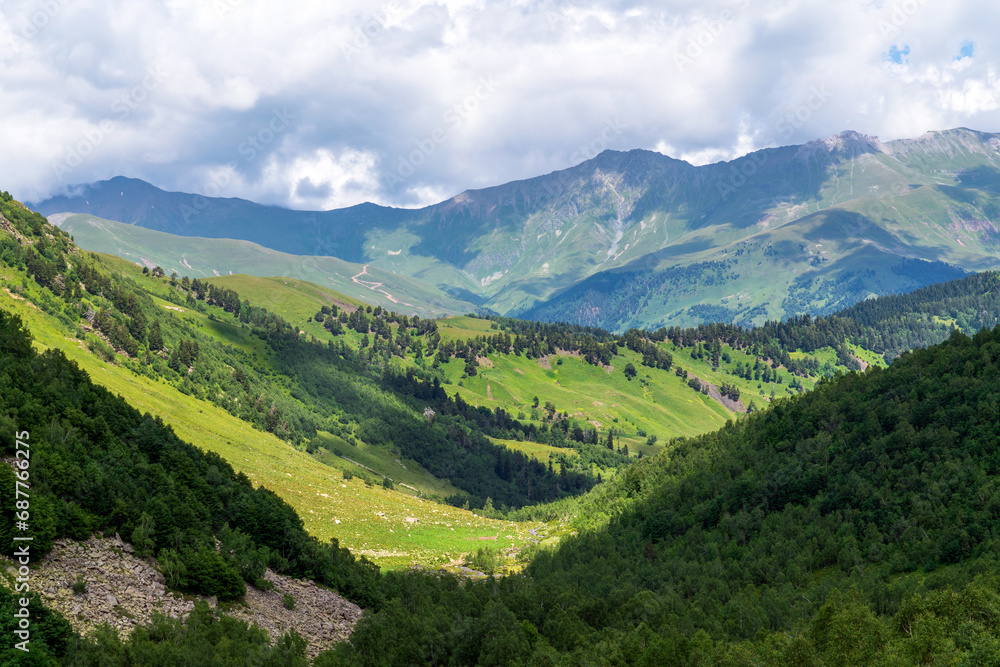 The valley of the Malaya Dukka River surrounded by the mountains of the North Caucasus and the tourist trail to the Dukka Lakes on a sunny summer day, Arkhyz, Karachay-Cherkessia, Russia