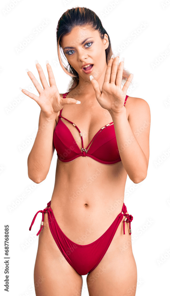 Fototapeta premium Young beautiful woman wearing bikini doing stop gesture with hands palms, angry and frustration expression