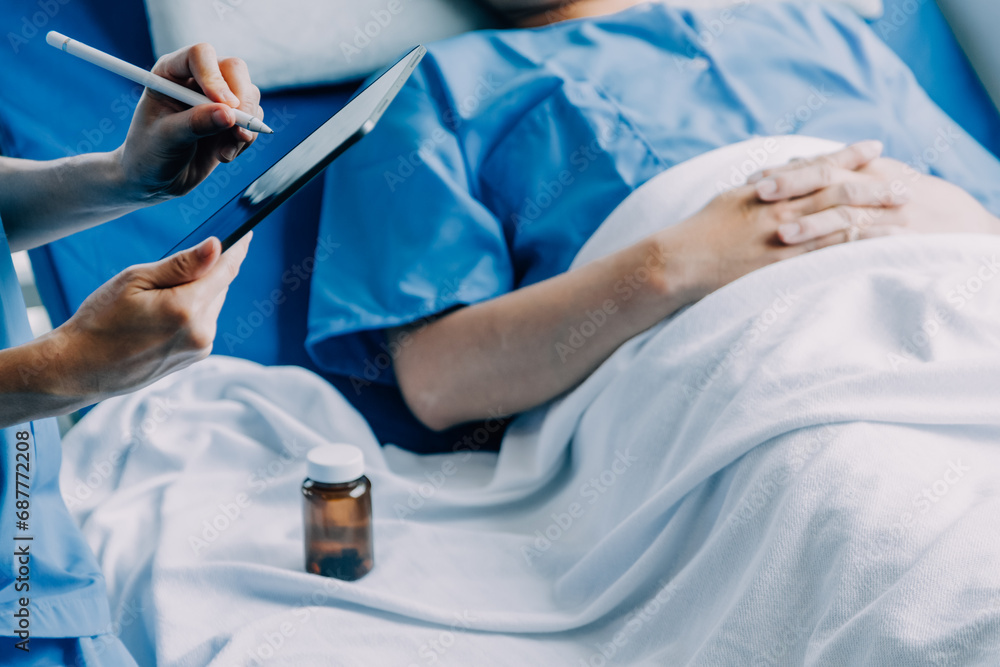 Side view of diverse doctors examining Asian female patient in bed in ward at hospital. Side view of diverse doctors examining Asian female patient in bed in ward at hospital.