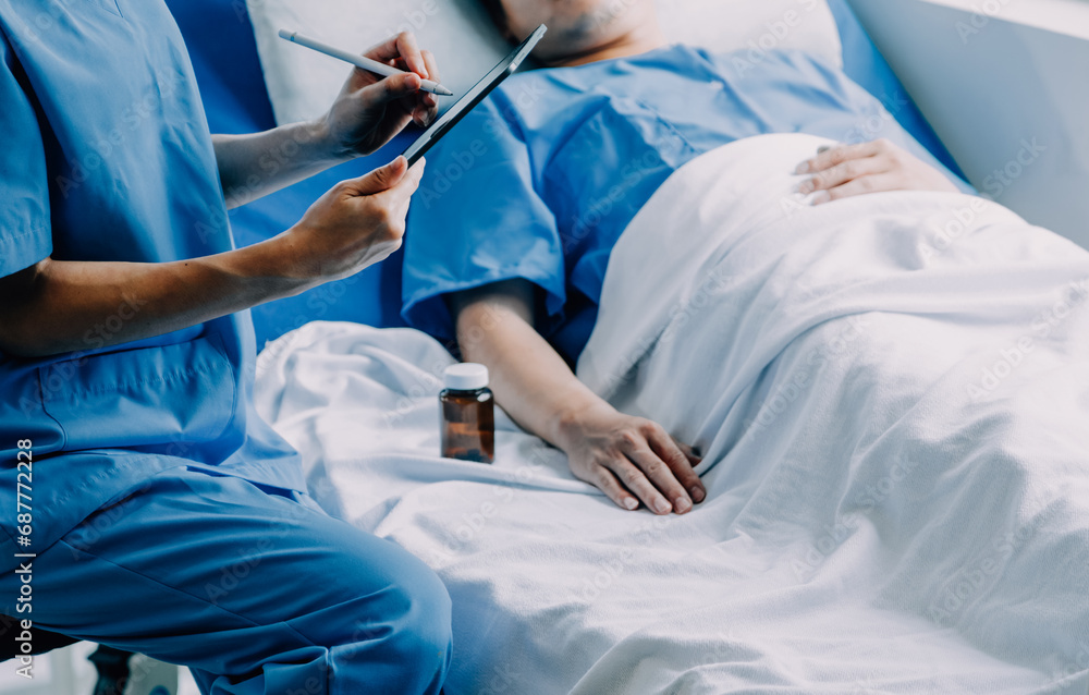 Side view of diverse doctors examining Asian female patient in bed in ward at hospital. Side view of diverse doctors examining Asian female patient in bed in ward at hospital.