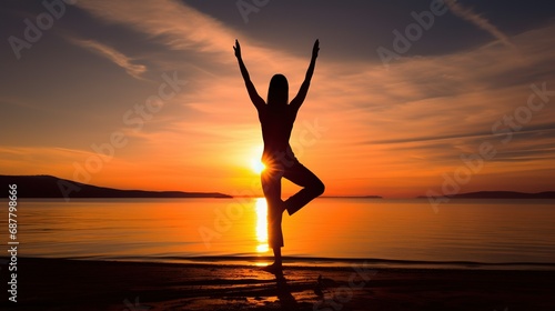 Silhouette of young woman practicing yoga on the beach at sunset  Young woman practicing yoga in the Natarajasana position