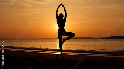 Silhouette of young woman practicing yoga on the beach at sunset, Young woman practicing yoga in the Natarajasana position