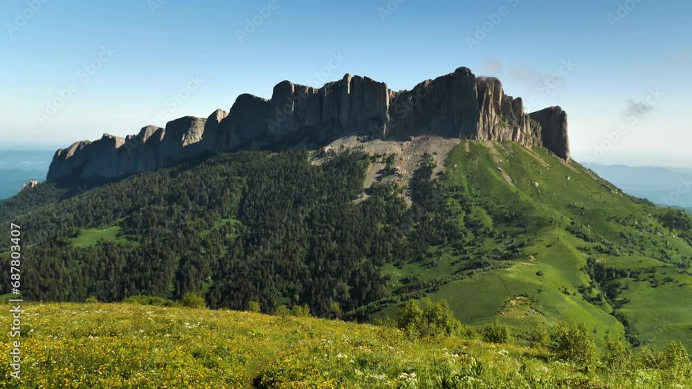 View of the majestic mountain, which is a long steep rock wall. Mount Bolshoi Tkhach in southern Russia. Smooth recoil with the camera View of the majestic mountain, which is a long steep rock wall. Mount Bolshoi Tkhach in southern Russia. Smooth recoil with the camera