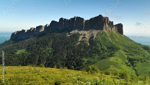 View of the majestic mountain, which is a long steep rock wall. Mount Bolshoi Tkhach in southern Russia. Smooth recoil with the camera photo