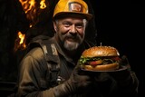 A miner holds a huge burger in his hands in a mine, lunch break for miner workers.